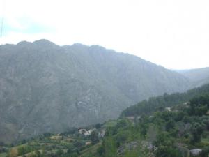 una vista sulle montagne di una valle con alberi e case di A casa do pátio a Montalegre