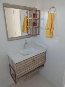 La salle de bains est pourvue d'un lavabo et d'un miroir. dans l'établissement Apartamento Novo 500m da praia de Itajuba, à Barra Velha