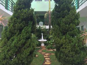 un jardín entre dos árboles con una fuente en el medio en Hotel Pousada Reimar, en Balneário Camboriú