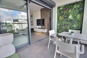 a room with a table and chairs and a tv at Appartement Sky Blue in Fort-de-France