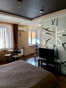 Habitación de hotel con cama y escritorio con TV. en Kharkiv Apartment , Prospect Nauki 19A, en Járkov