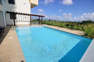a swimming pool in front of a house at Appartement Sky Blue in Fort-de-France
