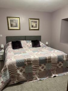 Un dormitorio con una cama con una manta. en White Side Cottage, en Haltwhistle