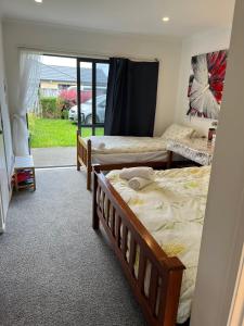 a bedroom with two beds and a door to a yard at Sunny self checkin studio with private entry& ensuite&heat pump in Hamilton