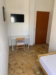 Habitación con mesa, silla y TV. en Daniele rooms en Arezzo