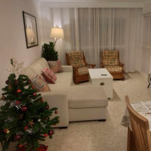 - un salon avec un arbre de Noël et un canapé dans l'établissement ApartRincón Sorolla, à Rincón de la Victoria