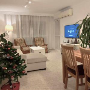 un salon avec un arbre de Noël et une télévision dans l'établissement ApartRincón Sorolla, à Rincón de la Victoria