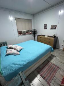 ein Schlafzimmer mit einem großen blauen Bett und einem Fenster in der Unterkunft Casas en Solis - Las Negritas in Balneario Solís