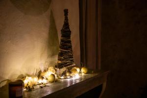 ein Kaminmantel mit einem Weihnachtsbaum und Lichtern in der Unterkunft Châteauneuf Suites in Châteauneuf