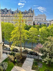 a tree in a park in front of a building at Avenue Montaigne Paris Bienvenue in Paris