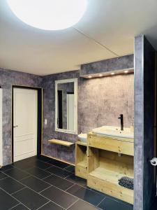 uma casa de banho com uma banheira, um lavatório e um espelho. em Bed and breakfast aan de grens em Lanaken