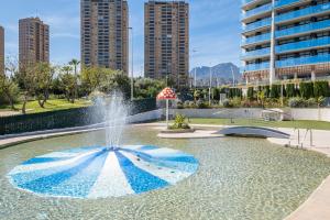 een fontein in een park met hoge gebouwen op de achtergrond bij Sunset Drive Resort Apartment 4-8 Poniente Beach in Benidorm