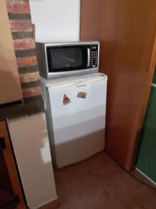 a microwave sitting on top of a refrigerator at MAE in Esquel