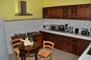 a kitchen with a table and chairs and a microwave at Villa Sundara Mauritius in Trou aux Biches