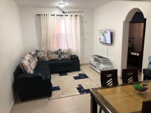 ein Wohnzimmer mit einem Sofa und einem Tisch in der Unterkunft Leisure apartment in Mombasa