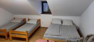 two twin beds in a room with a window at Pokoje u Juroszka in Istebna