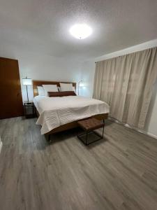 een slaapkamer met een groot bed en houten vloeren bij Arabi's Cozy & Quiet Getaway 