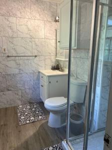 een badkamer met een toilet en een douche bij Arabi's Cozy & Quiet Getaway 