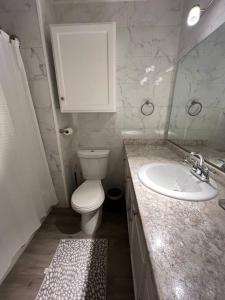 的住宿－Arabi's Cozy & Quiet Getaway，白色的浴室设有卫生间和水槽。