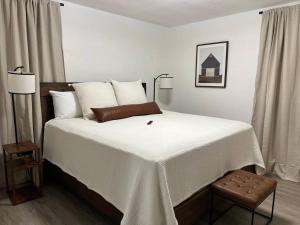 een slaapkamer met een groot bed met witte lakens bij Arabi's Cozy & Quiet Getaway 