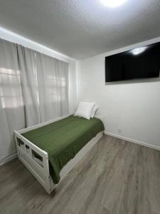 的住宿－Arabi's Cozy & Quiet Getaway，一间卧室配有一张床和一台平面电视