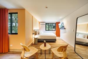 a bedroom with a bed and a table and chairs at The Somos Central Hotel Poblado in Medellín