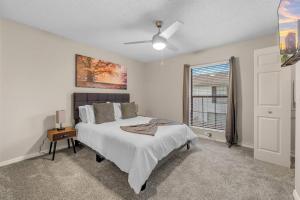 タンパにあるCozy Townhouse - Gym Pool Golf Fast WiFi 2B2Bのベッドと窓のある白い寝室 +19枚の写真