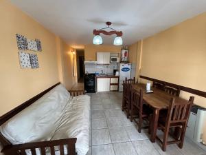 Habitación con cama, mesa y cocina. en Complejo Berilde I en San Clemente del Tuyú