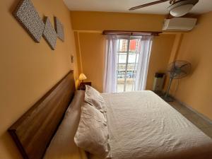 1 dormitorio con 1 cama y ventana con ventilador en Complejo Berilde I en San Clemente del Tuyú