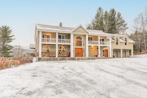 a house on a snow covered road at Maplewood Manor 8BR, Hot Tub, Gym, Fire Pit in Jewett