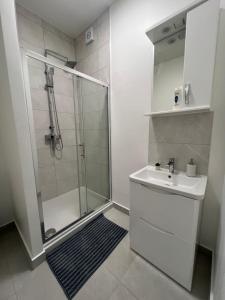 a white bathroom with a shower and a sink at London Comfort Stay in London