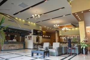 a lobby of a hotel with chairs and tables at Asenappar Hotel in Erbil