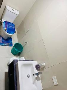 a bathroom with a toilet and a sink in it at Vacation homes metrogate estate in Silang