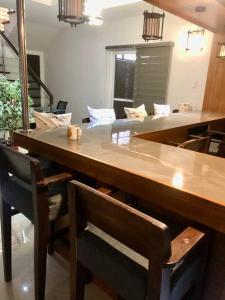 a large wooden table with chairs and a counter top at Vacation homes metrogate estate in Silang