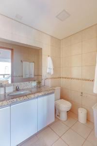 ein Badezimmer mit einem Waschbecken, einem WC und einem Spiegel in der Unterkunft Bangalô 41, Uma Boa Ideia! in Porto De Galinhas
