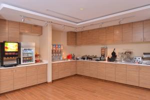 TownePlace Suites by Marriott Gillette في جيليت: مطبخ كبير مع دواليب خشبية وتلفزيون