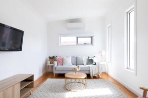 a living room with a couch and a tv at Elwood Star- Beachside Retreat in Melbourne