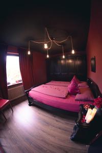 1 dormitorio con 1 cama grande con sábanas rosas en Erwachsenenhotel BDSM Apartment Hotel Emotion Apartments mit privater Sauna & Whirlpool en Vlotho