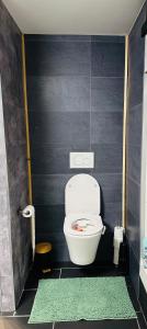 łazienka z toaletą i czarną ścianą w obiekcie Bed and breakfast aan de grens w mieście Lanaken