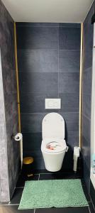 a bathroom with a toilet and a black wall at Bed and breakfast aan de grens in Lanaken