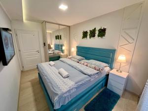 a bedroom with a blue bed and a mirror at Apartmani SLEEP&JOY in Zlatibor