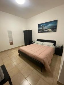 een slaapkamer met een bed en een schilderij aan de muur bij MicamAle in Modugno