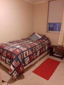 een slaapkamer met een bed en een rood tapijt bij Departamento en Laguna Vista in Algarrobo