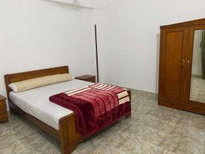 a bedroom with a bed and a wooden cabinet at Hadi Guest House in Luxor