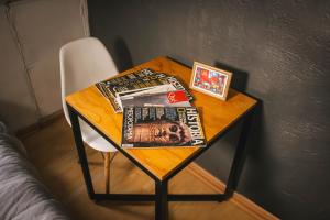 una mesa con revistas y una silla junto a una cama en Hostal Salvador, en Santiago