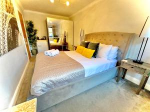 a bedroom with a large bed with yellow pillows at Simply relax in London