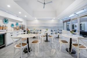 a dining room with white tables and chairs at The Normandy Hotel in Washington