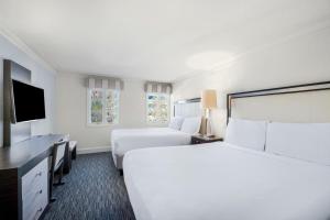 a hotel room with two beds and a flat screen tv at The Normandy Hotel in Washington, D.C.