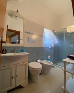 La salle de bains est pourvue de toilettes, d'un lavabo et d'un miroir. dans l'établissement Holiday House Ginevra, à Formia
