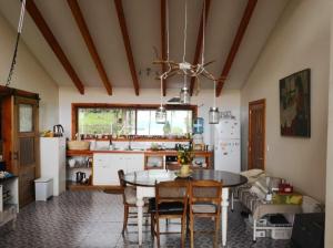 a kitchen with a table and some chairs in a room at Habitación doble en Parcela en Lago Ranco in Lago Ranco